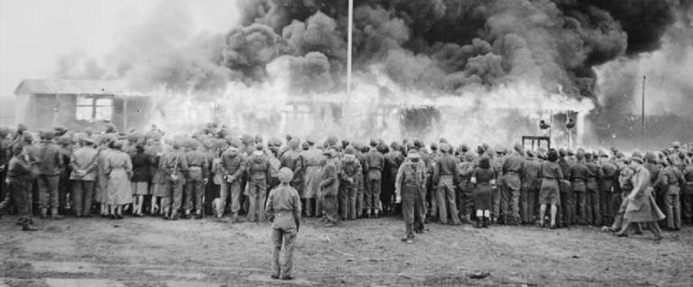 The Liberation of Bergen-belsen Concentration Camp, May 1945. Crowds watch the destruction of the last hut at Belsen two days after the camp was finally evacuated. The hut was set on fire by a British flamethrower.