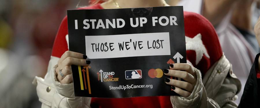 A fan holds up their sign for the Stand Up To Cancer program prior to the sixth inning in Game Four of the 2019 World Series between the Houston Astros and the Washington Nationals at Nationals Park on October 26, 2019 in Washington, DC.