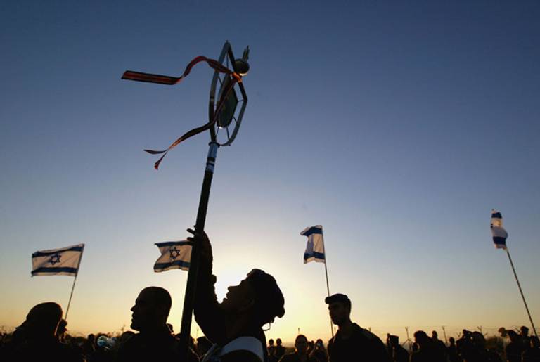 Israeli soldiers take part in a flag-lowering ceremony as they prepare to withdraw from the army headquarters September 11, 2005 in Gush Katif in the southern Gaza Strip. (Uriel Sinai/Getty Images)