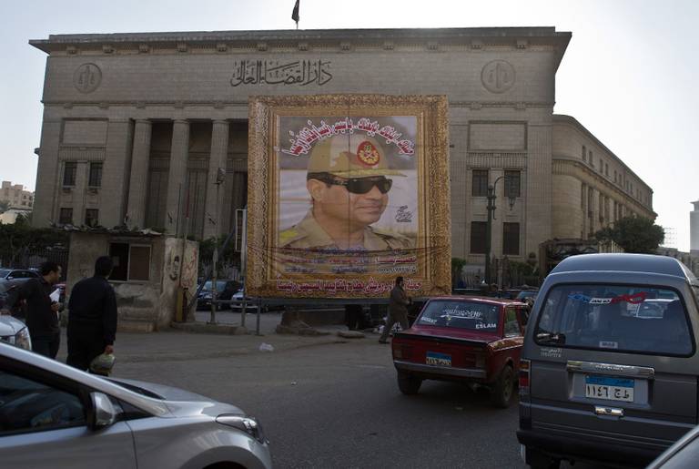 Egyptians walk past a huge poster of Egypt's former Defense Minister and armed forces chief General Abdul Fatah Al-Sisi outside the High Court in downtown Cairo, on March 27, 2014.(Khaled Desouki/AFP/Getty Images)