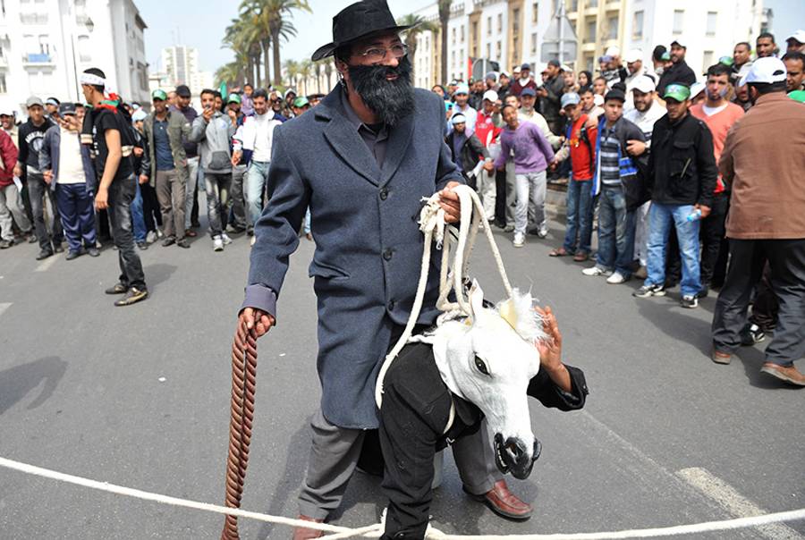 A Moroccan dressed as a Jew sits on a compatriot wearing a fake donkey's head and acting as a donkey to symbolize Arab regimes, as they take part in a protest against the participation of the Israeli delegation at the 8th session of the parliamentary assembly of the Mediterranean Union in front of the Parliament in Rabat, on March 25, 2012.(Aida/AFP/Getty Images)