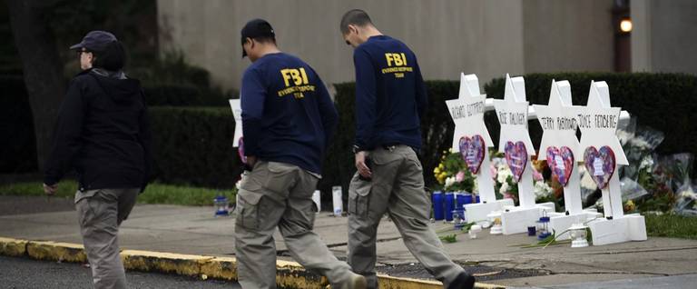 Members of the FBI walk past a memorial outside the Tree of Life synagogue after a shooting there left 11 people dead in the Squirrel Hill neighborhood of Pittsburgh on Oct. 27, 2018.