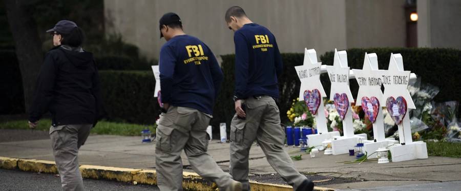 Members of the FBI walk past a memorial outside the Tree of Life synagogue after a shooting there left 11 people dead in the Squirrel Hill neighborhood of Pittsburgh on Oct. 27, 2018.