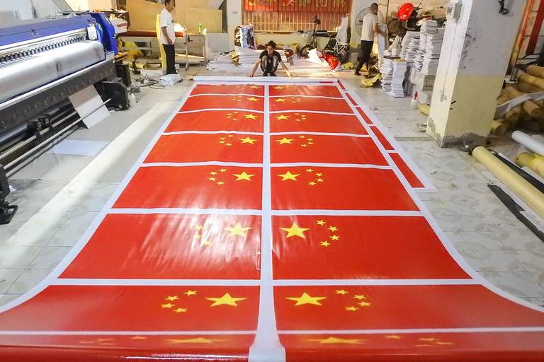 Workers produce inkjet-printed national flags at a factory in Lianyungang in China’s eastern Jiangsu province on Sept. 17, 2019, ahead of the 70th anniversary of the founding of the People’s Republic of China
