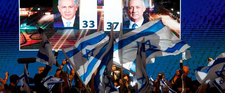 Supporters of the Blue and White (Kahol Lavan) political alliance watch a TV poll on a screen at the alliance headquarters in Tel Aviv on April 9, 2019