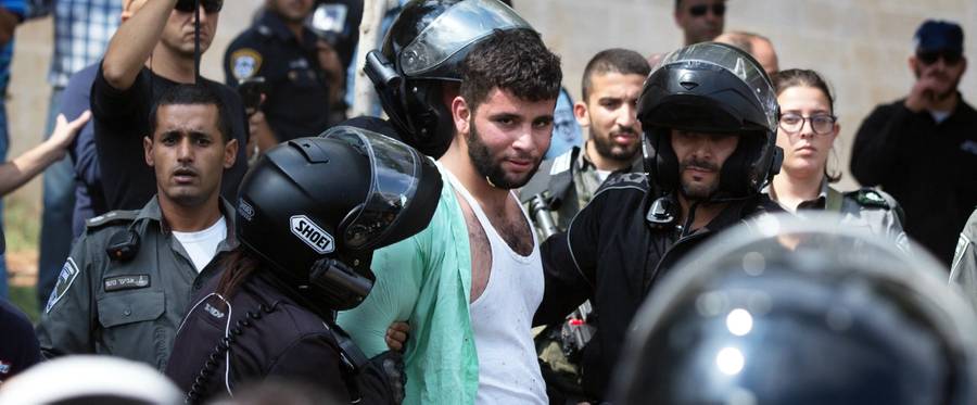 Israeli policemen detain a Palestinian man (C) after stabbing a Jewish teenager in Jerusalem, October 9, 2015. 