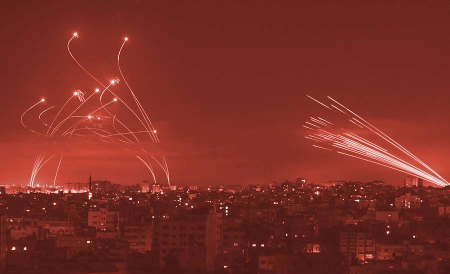 Israel’s Iron Dome missile defense system (L) intercepts rockets (R) fired by Hamas towards southern Israel from Beit Lahia in the northern Gaza Strip on May 14, 2021.