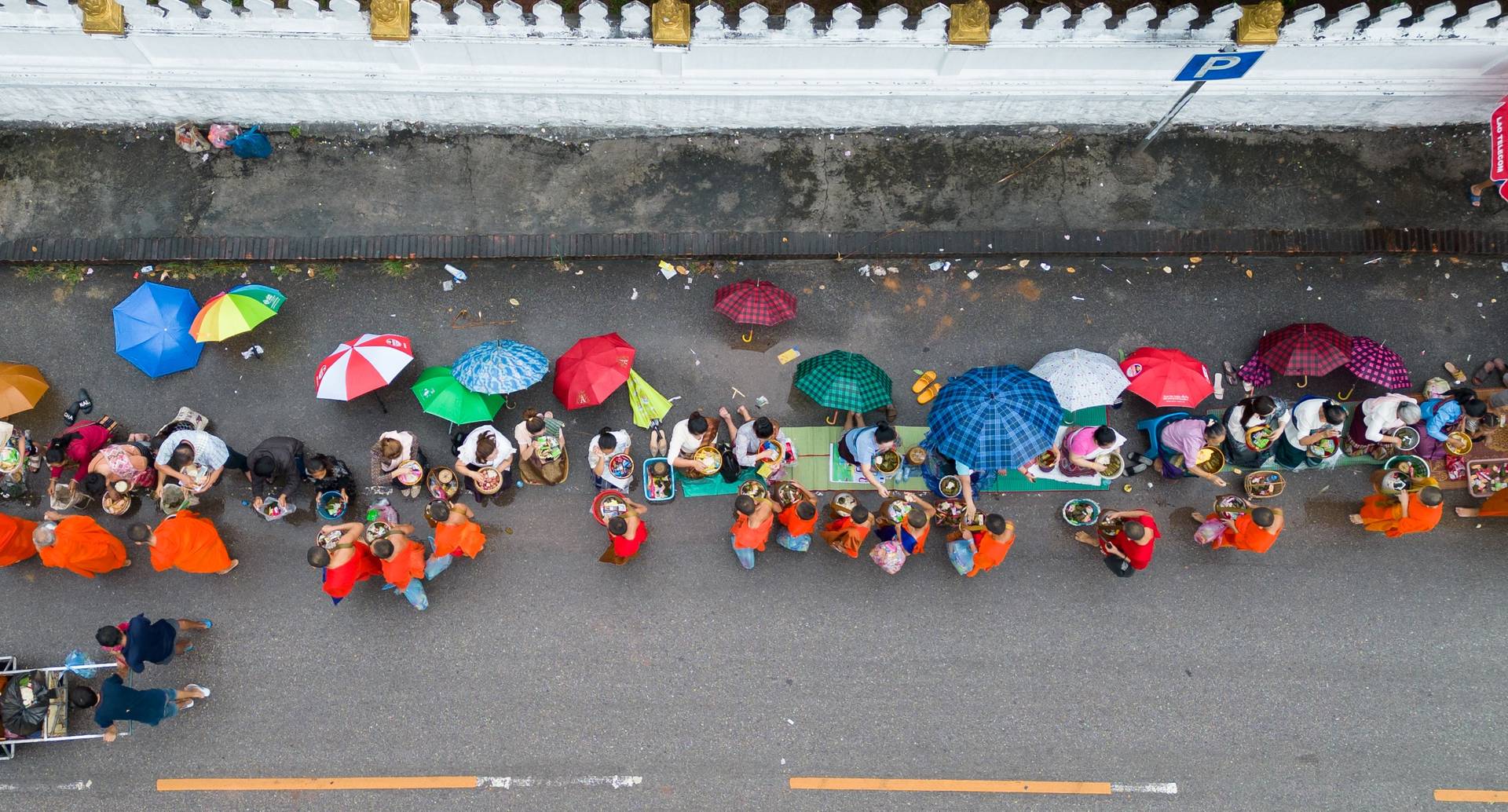 People offering alms to Buddhist monks in Luang Prabang, Laos