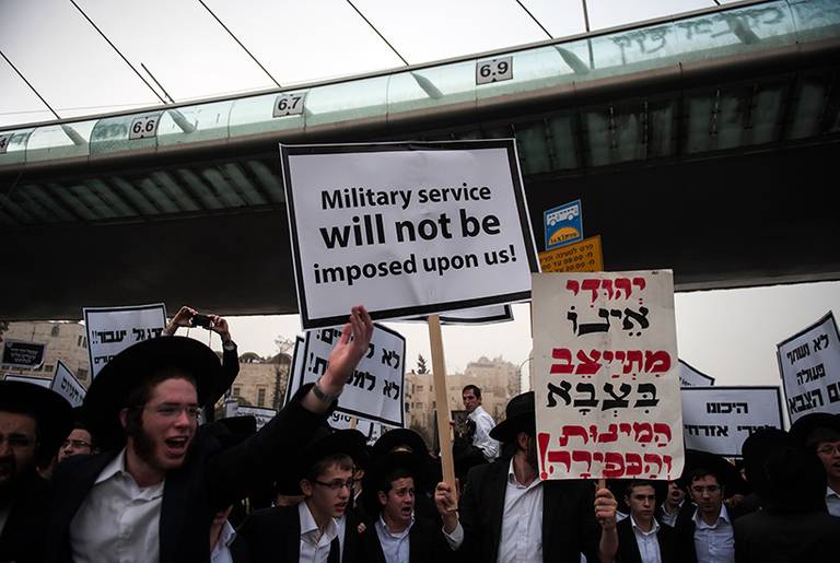 Ultra-Orthodox Jews holding a placard that reads in English "Military service will not be imposed upon us" take part in a mass prayer vigil in Jerusalem on March 2, 2014, in protest at plans to conscript young ultra-Orthodox men for Israeli military or civilian service. (David Buimovitch/AFP/Getty Images)