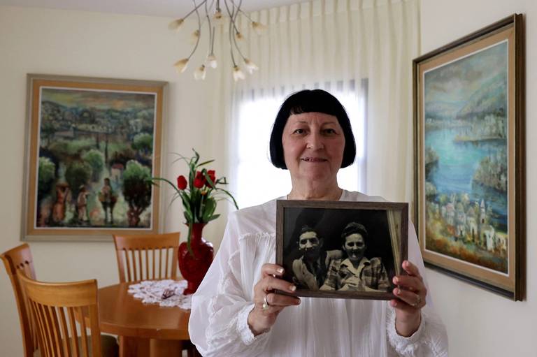 Shoshana Greenberg, 74, the daughter of a Holocaust survivor, holding a portrait of her parents Regina and Israel, at her home in Tel Aviv, July 18, 2021.  For Shoshana Greenberg, a new law making its way through the Polish parliament means abandoning any hope of compensation for the properties taken from her family during World War II. 