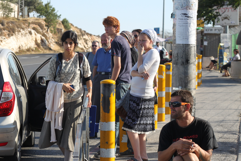 Hitchhikers wait for rides south from the Gilo trempiada in Jerusalem in June.(Photo by Daniel Estrin)