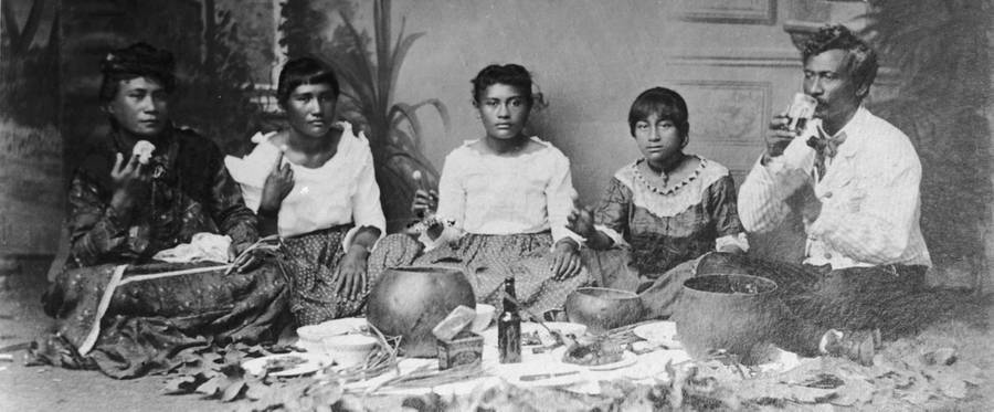 Portrait of Native Hawaiian family sitting on the floor eating poi, Hawai‘i, 1907.