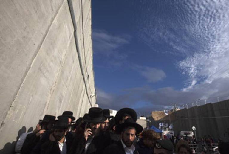 Ultra-Orthodox Jews walk near a concrete wall built to protect Rachel's Tomb.(Menahem Kahana/AFP/Getty Images)
