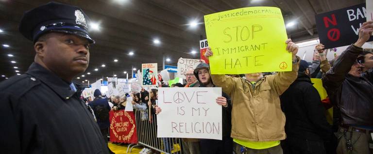 A police officer stands guard as demonstrators at Philadelphia International Airport protest against the executive order that President Donald Trump signed clamping down on refugee admissions and temporarily restricting travelers from seven predominantly Muslim countries on January 29, 2017 in Philadelphia, Pennsylvania. Demonstrators gathered at airports across the country in protest of the order.