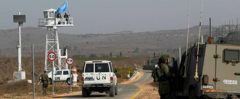 Two U.N. white jeeps cross into Israeli-controlled territory through the reopened crossing near Quneitra in the Golan Heights on Oct. 15, 2018. 