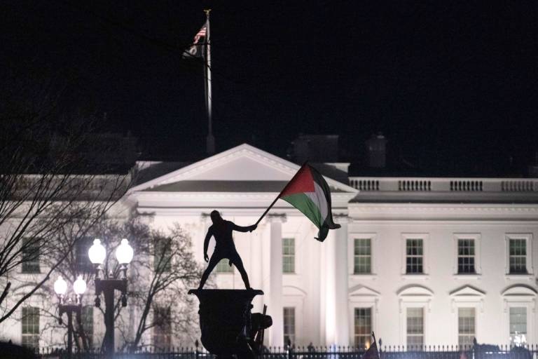 A pro-Palestinian demonstrator waves a Palestinian flag near the White House during the ‘March on Washington for Gaza’ on Jan. 13, 2024