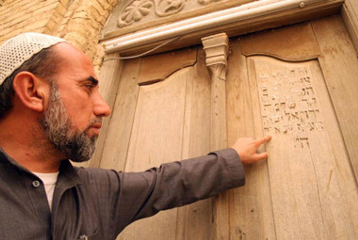 A Shiite Muslim Iraqi who cares for the shrine of Ezra, near Basra, points to some Hebrew etching on what was once a holy ark.(AFP/Getty Images)