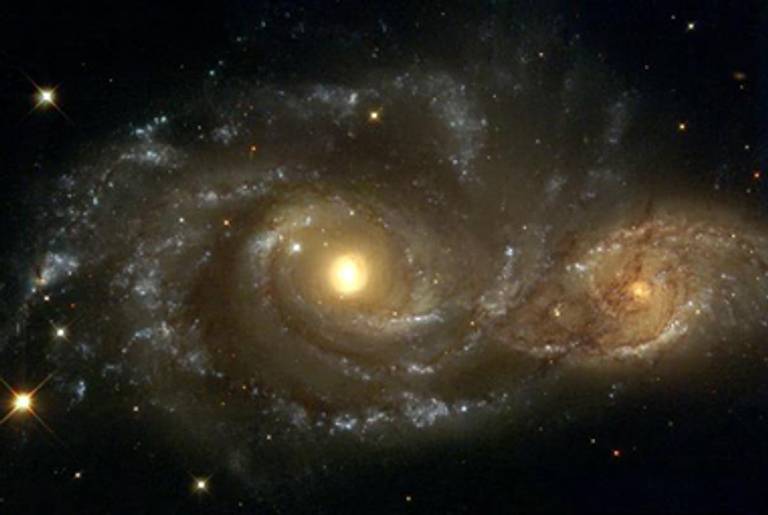 Two spiral galaxies pass by each other in the direction of the constellation Canis Major, in an image from the Hubble Space Telescope.(NASA, ESA, and The Hubble Heritage Team)