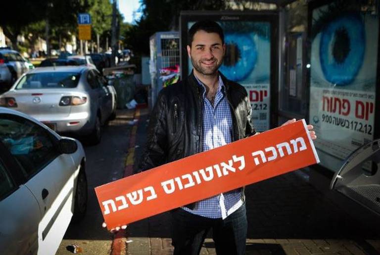 Mickey Gitzin stands with a sign: "Waiting for a bus on Shabbat."(Eyal Yassky-Weiss)