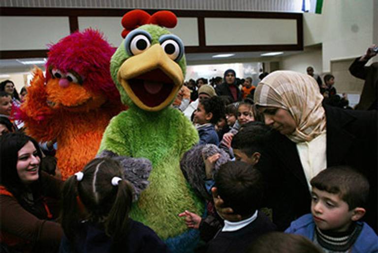 The Shara’a Simsim characters Karim (green) and Haneen at a Palestinian school in March.(NYTimes.com)