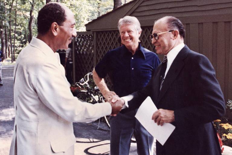Former Egyptian President Anwar al-Sadat shakes hands with former Israeli Premier Menachem Begin as former US President Jimmy Carter looks on, September 6, 1978 at Camp David.(KARL SCHUMACHER/AFP/Getty Images)