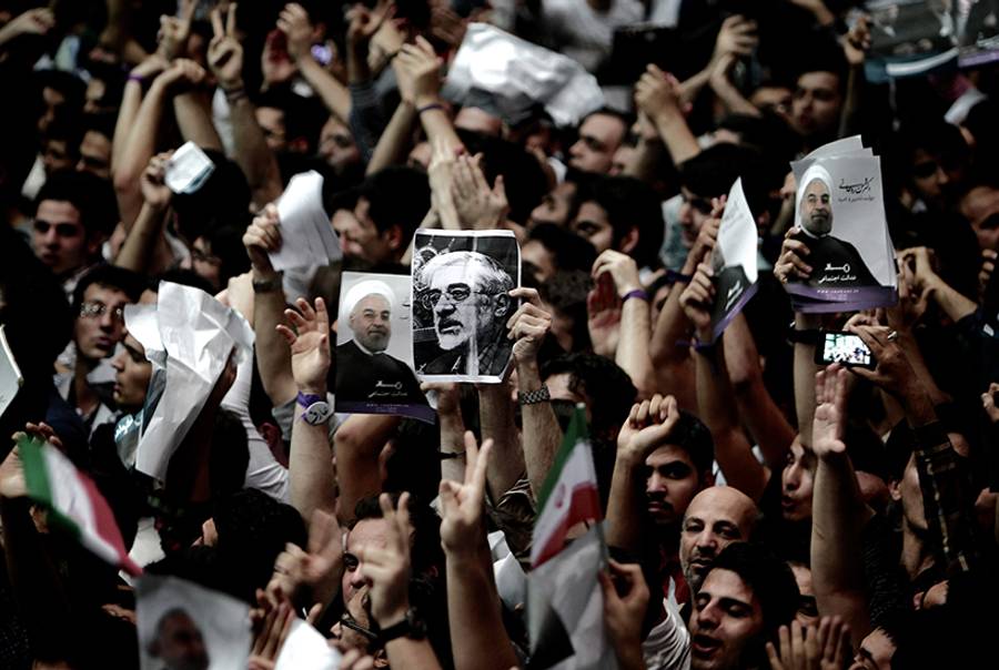 A supporter of Iranian former Vice-President Mohammad Reza Aref holds a portrait of opposition leader Mir Hossein Mousavi, who is under house arrest since February 2011, during a campaign rally for Aref in Tehran on June 10, 2013.(Behrouz Mehri/AFP/Getty Images)