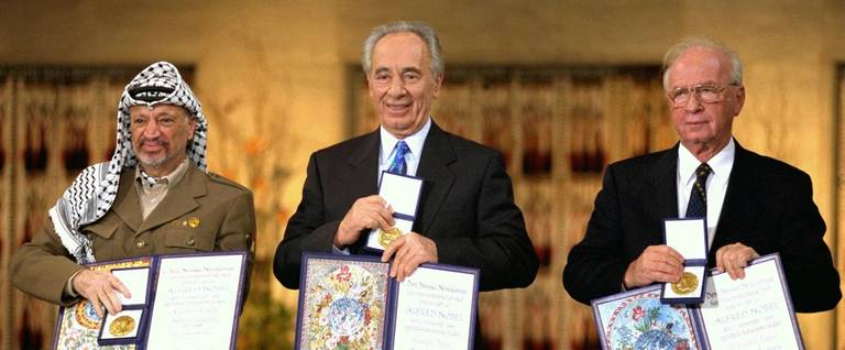 Palestinian leader Yasser Arafat (L), Israeli Foreign Minister Shimon Peres (C) and Israeli Premier Yitzhak Rabin display their Nobel Peace Prizes in Oslo, Norway, December 10, 1994. 