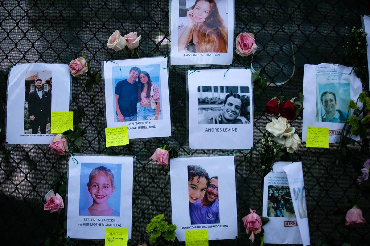 Photos of missing residents are posted at a makeshift memorial at the site of a collapsed building in Surfside, Florida, June 26, 2021