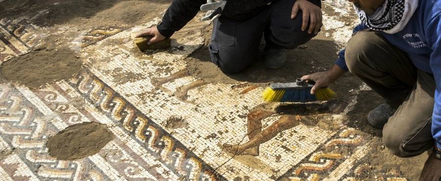 Workers from the Israeli Antiquity Authority (IAA) clean a rare Roman mosaic from the 2nd-3rd centuries at the Israeli Caesarea National Park on February 8, 2018.