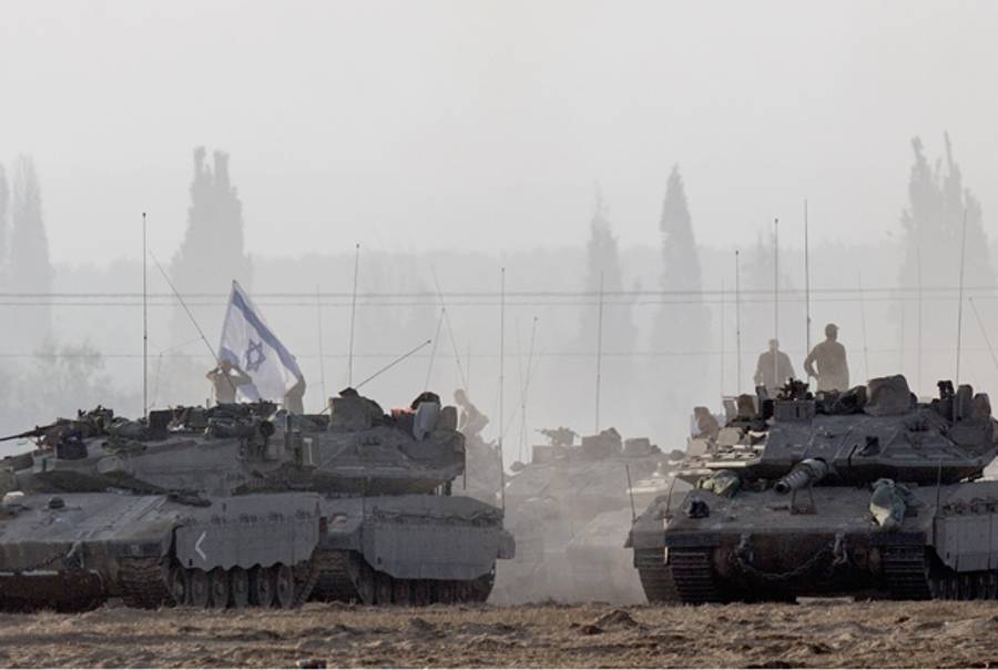 Israeli soldiers stand on Merkava tanks in an army deployment area near Israel's border with the Gaza Strip on July 8, 2014. (JACK GUEZ/AFP/Getty Images)
