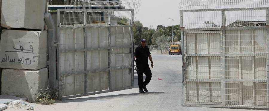 A Palestinian security officer closes the gate under Palestinian control at the Kerem Shalom crossing between Israel and the southern Gaza Strip, south of Rafah on June 7, 2015. This came after Israel closed, until further notice, the Erez crossing, and the Kerem Shalom crossing for goods, as Gaza militants resumed their rocket fire on southern Israel after warplanes blitzed the coastal enclave. 