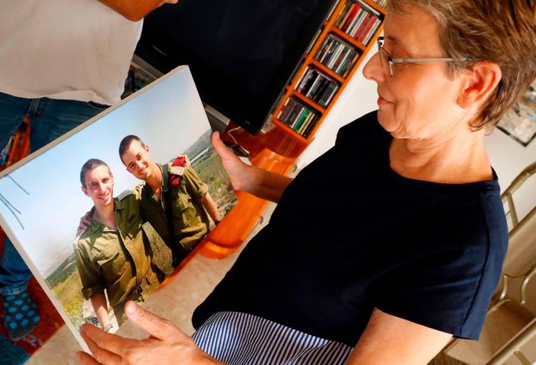 Leah Goldin holds up a picture of her son, Israeli soldier Lieutenant Hadar Goldin, at left in photo, as she speaks during an interview with AFP at their family home in the central Israeli city of Kfar Saba on Aug. 29, 2018