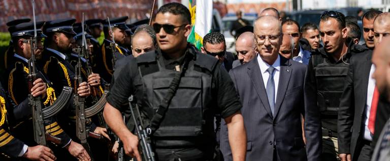 Palestinian Prime Minister Rami Hamdallah, escorted by his bodyguards, is greeted by police forces of Hamas upon his arrival in Gaza City on March 13, 2018.