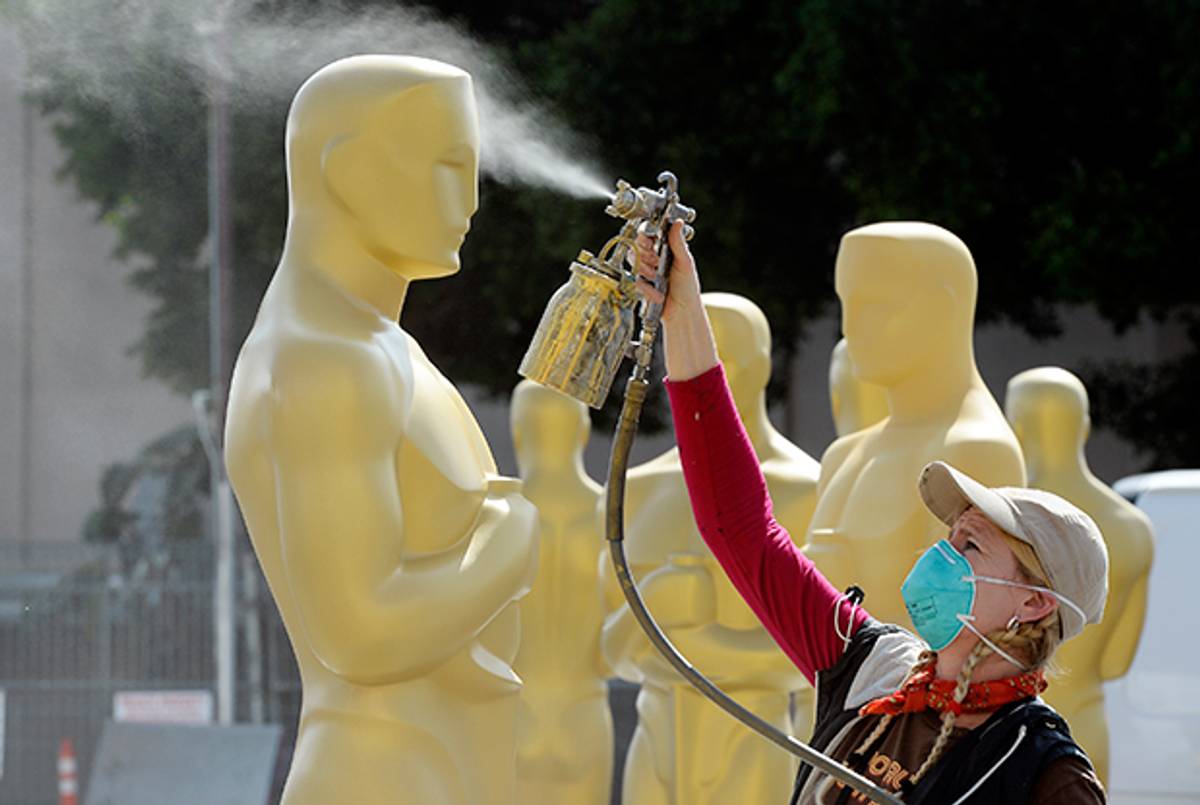 Dena D'Angelo spray paints an Oscar statue with gold color during preparation of 87th Annual Academy Awards February 18, 2015 in Hollywood, California. (Kevork Djansezian/Getty Images)