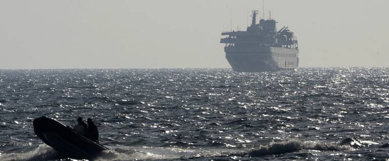 A speed boat escorts Turkish ship Mavi Marmara with Israeli troops on board near the southern port of Ashdod on May 31, 2010, after the Israeli navy raided a flotilla of ships bound for Gaza.