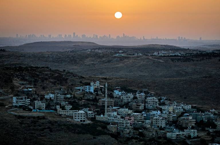 The occupied West Bank northwest of the Palestinian city of Ramallah, and the skyline of Tel Aviv, June 17, 2020