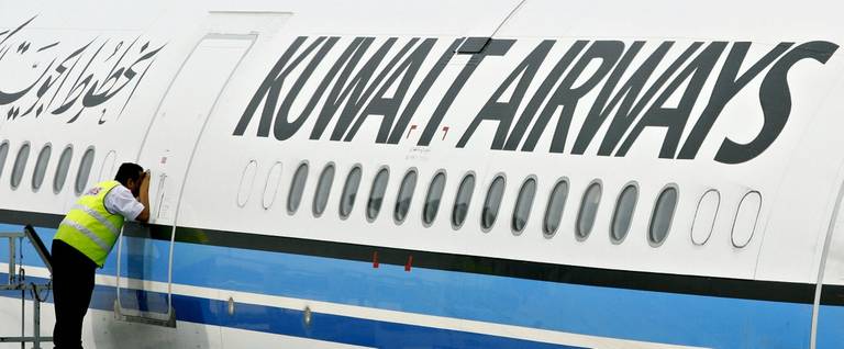A ground crew member takes a peek inside the cabin of a Kuwait Airways Airbus A340 at the Kuala Lumpur International Airport in Sepang, Malaysia, November 1, 2006. 