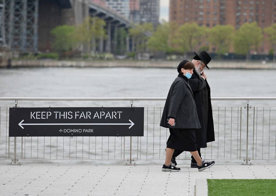 A couple walks in Brooklyn’s Domino Park on May 11, 2020