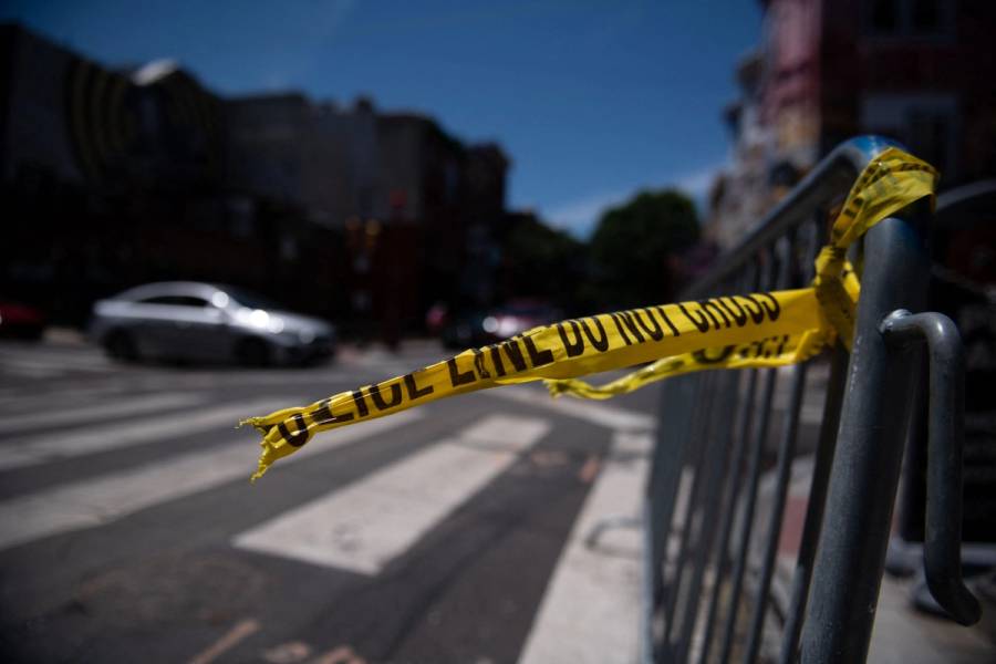 Police tape hangs from a barricade at the corner of South and 3rd streets in Philadelphia on June 5, 2022, the day after three people were killed and 11 others wounded by gunfire all within a few blocks