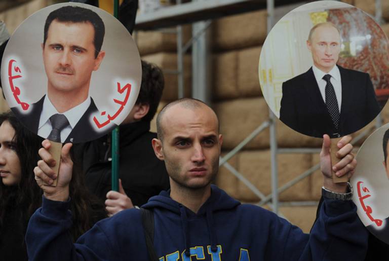 A man holds a portrait of Syria's President Bashar al-Assad and Russia's President Vladimir Putin during a rally in front of the U.S. Embassy in Moscow in support of the Syrian regime. Oct. 19, 2012.(Andrey Smirnov/AFP/Getty Images)