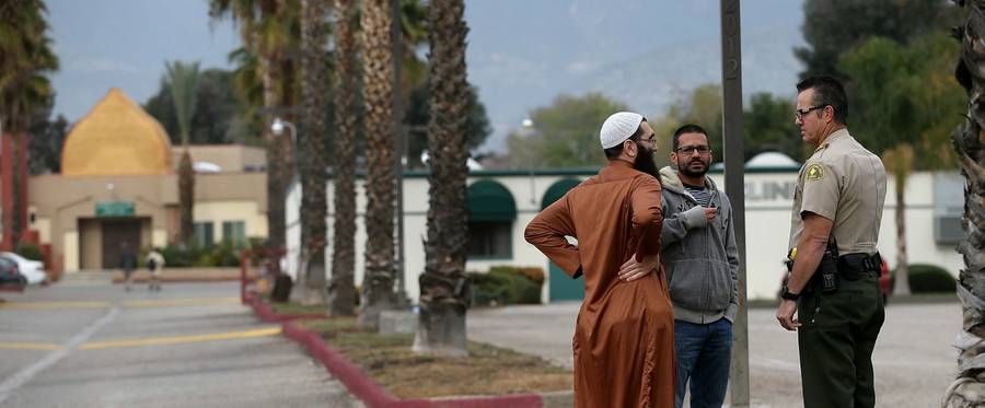 Members of the Dar-Al-Uloom, Al-Islamiyah of America mosque, where shooting suspect Syed Farook used to attend prayer services, talk with a San Bernardino County sheriff deputy  in San Bernardino, California, December 4, 2015. 