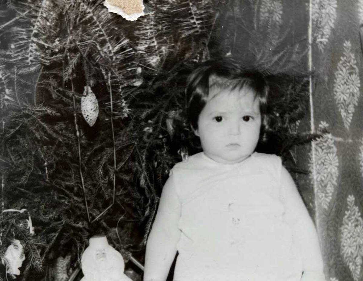 The author as a toddler under the Novy God tree, with a figure of Ded Moroz