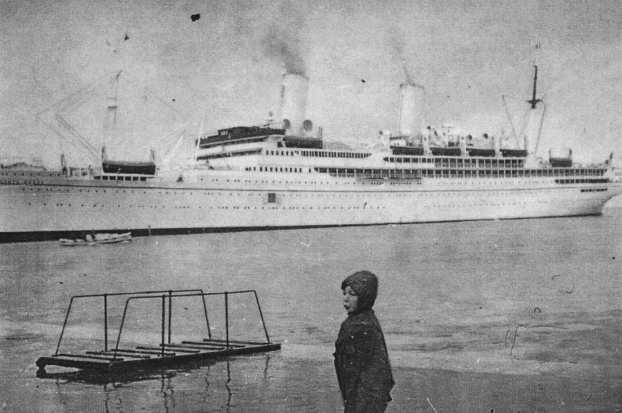 Four-year-old Bill Hant in front of SS Conte Rosso, the sister ship of SS Conte Verde, at the port of Trieste