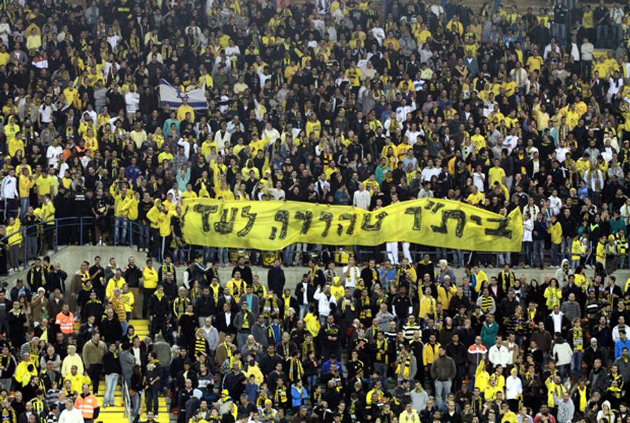 Fans of the Beitar Jerusalem soccer team hold up a banner in Hebrew that reads "Beitar Pure Forever" during a match in Jerusalem on Jan. 26, 2012.(AFP/Getty Images)