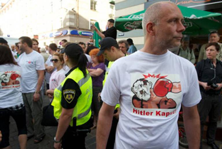 An opponent of the march watches it go down in Riga. Great t-shirt.(Ilmars Znotins/AFP/Getty Images)