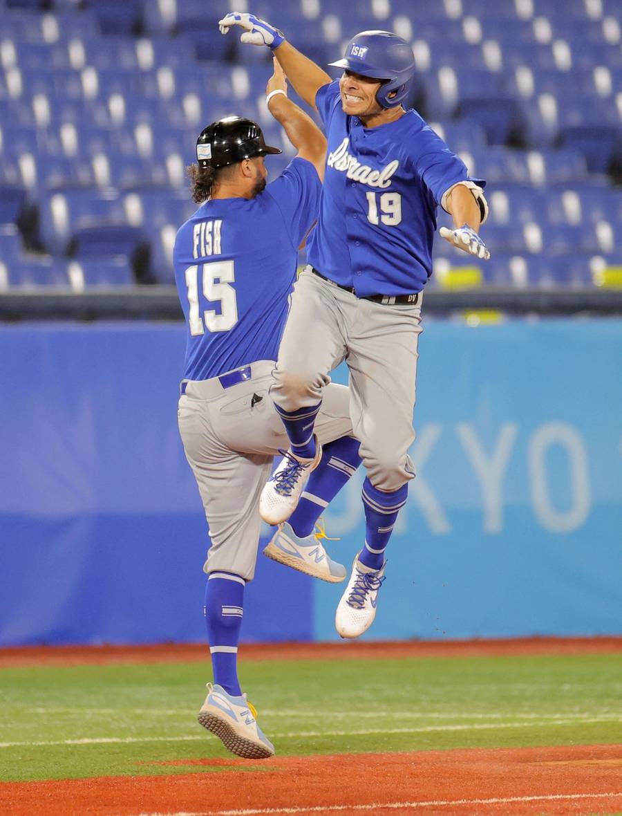 Israel’s Daniel Valencia, at right, celebrates his two-run home run with third-base coach Nate Fish, left, during the eighth inning of the Tokyo 2020 Olympic Games baseball round 1 game between Israel and the Dominican Republic at Japan’s Yokohama Baseball Stadium, on Aug. 3, 2021
