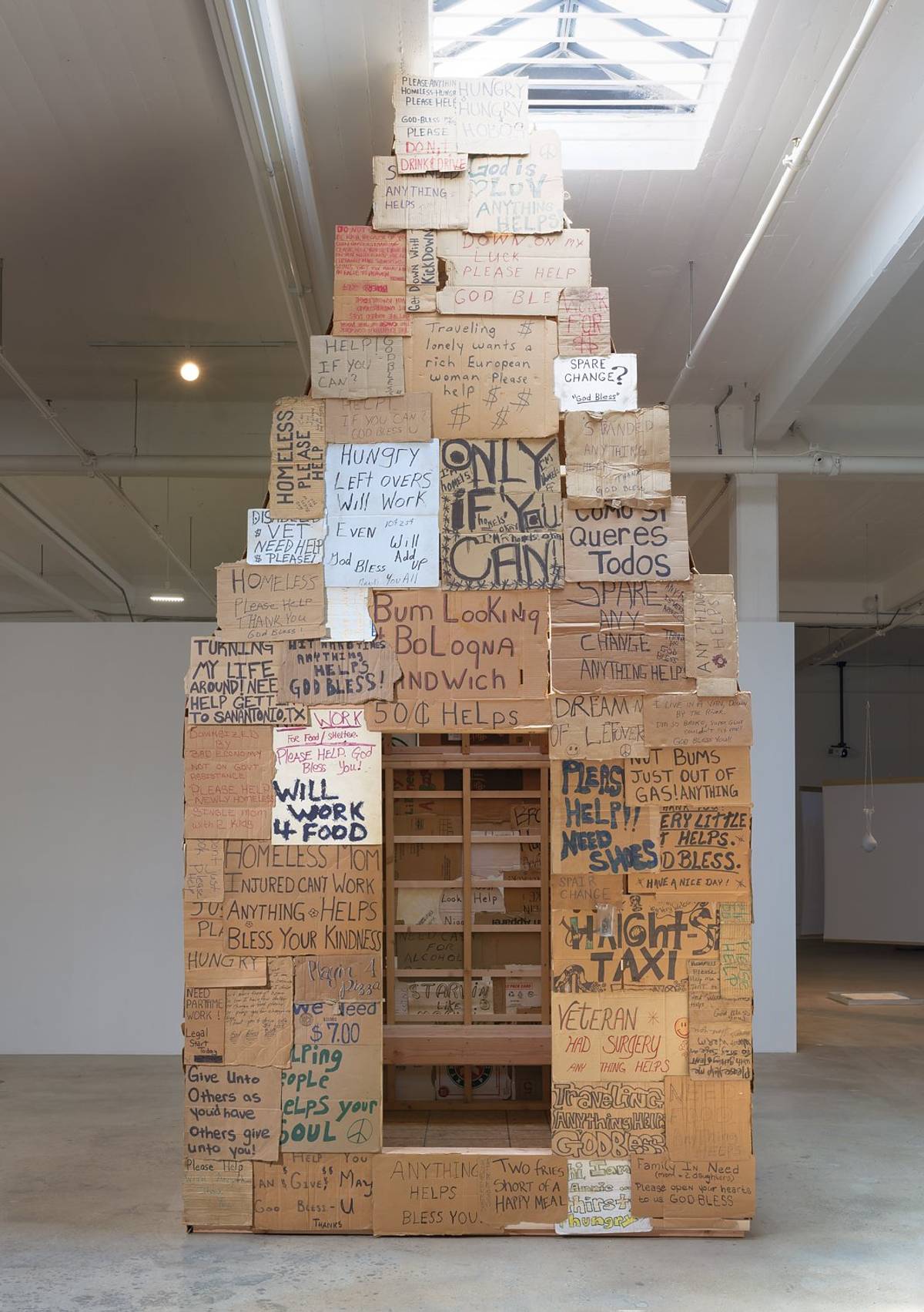 Rael San Fratello. 'Sukkah of the Signs/Homeless House,' 2021. Media: purchased and collected signs from homeless individuals, wood.