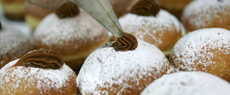 Sufganiyot are filled with caramel before going on display at the Roladin Bakery  in Kadima in central Israel, December 6, 2006. 