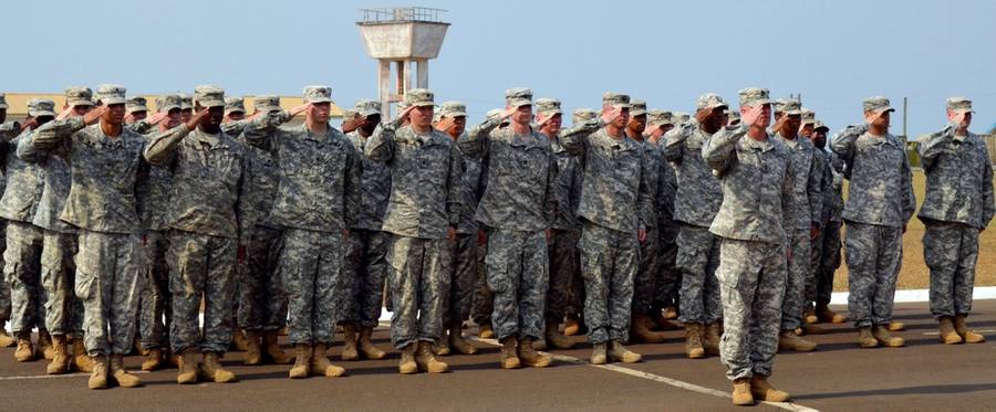 U.S. soldiers of the 101st Airborne Division (Air Assault) salute during the ceremonial folding and stowing of the flag at the Barclay Training Camp (BTC) in Monrovia, Liberia, February 26, 2015.