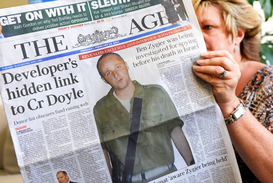 A woman poses with an Australian newspaper on Feb. 14, 2013, showing the front-page story about Ben Zygier, known as Prisoner X.(William West/AFP/Getty Images)